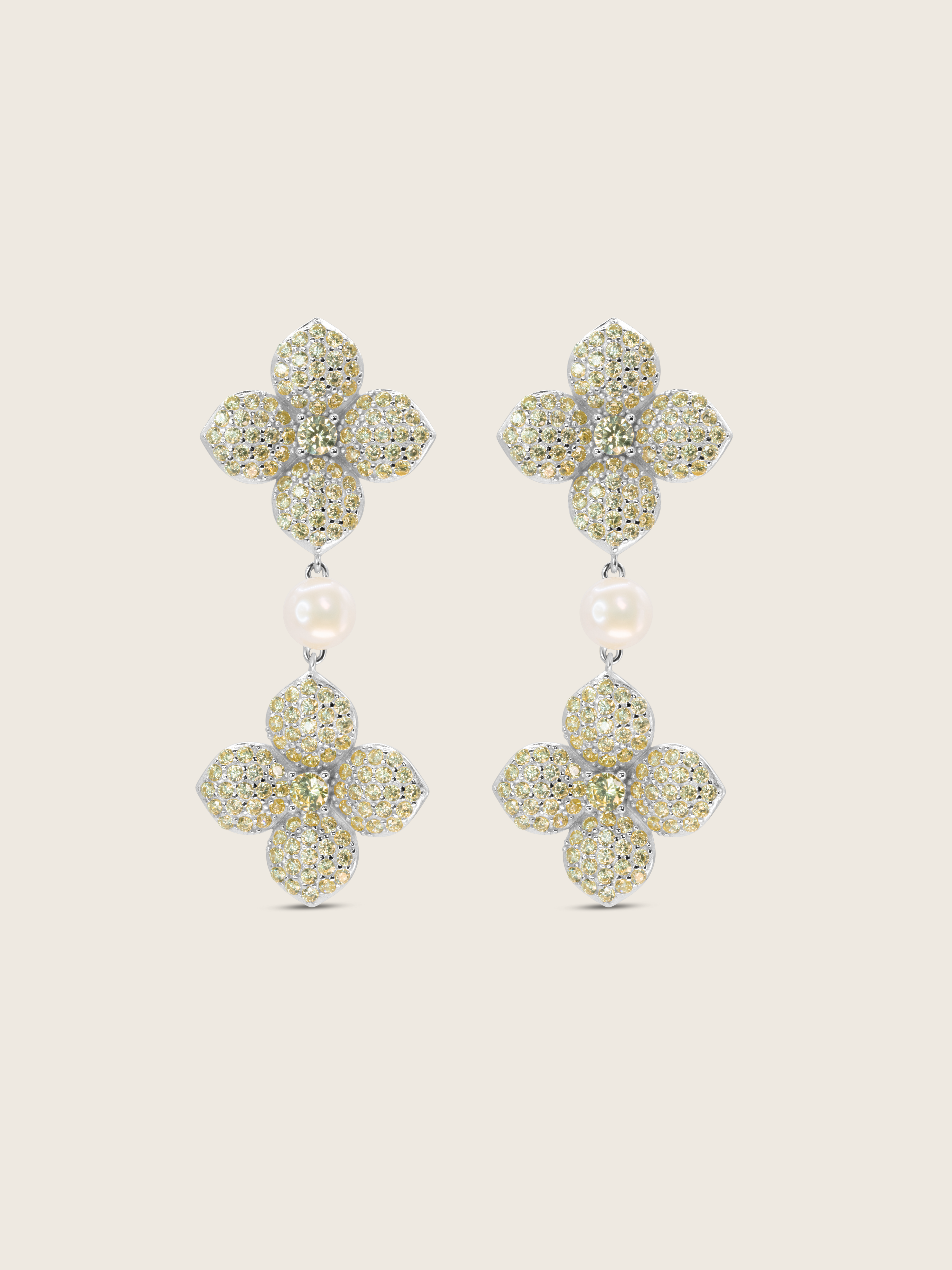 White gold plated hydrangea dangle earrings with yellow cubic zirconia stones and freshwater pearl on white background. Elegant floral drop earrings with sparkly detailing.