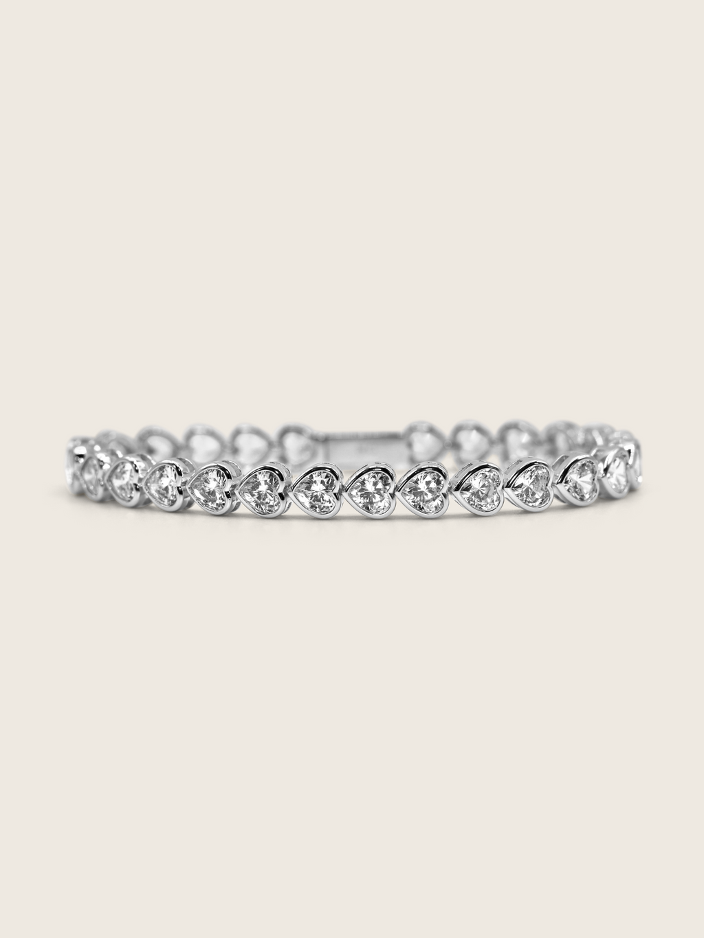 White gold plated heart tennis bracelet with bezel-set heart-cut cubic zirconia stones, a romantic and elegant twist on a classic silhouette