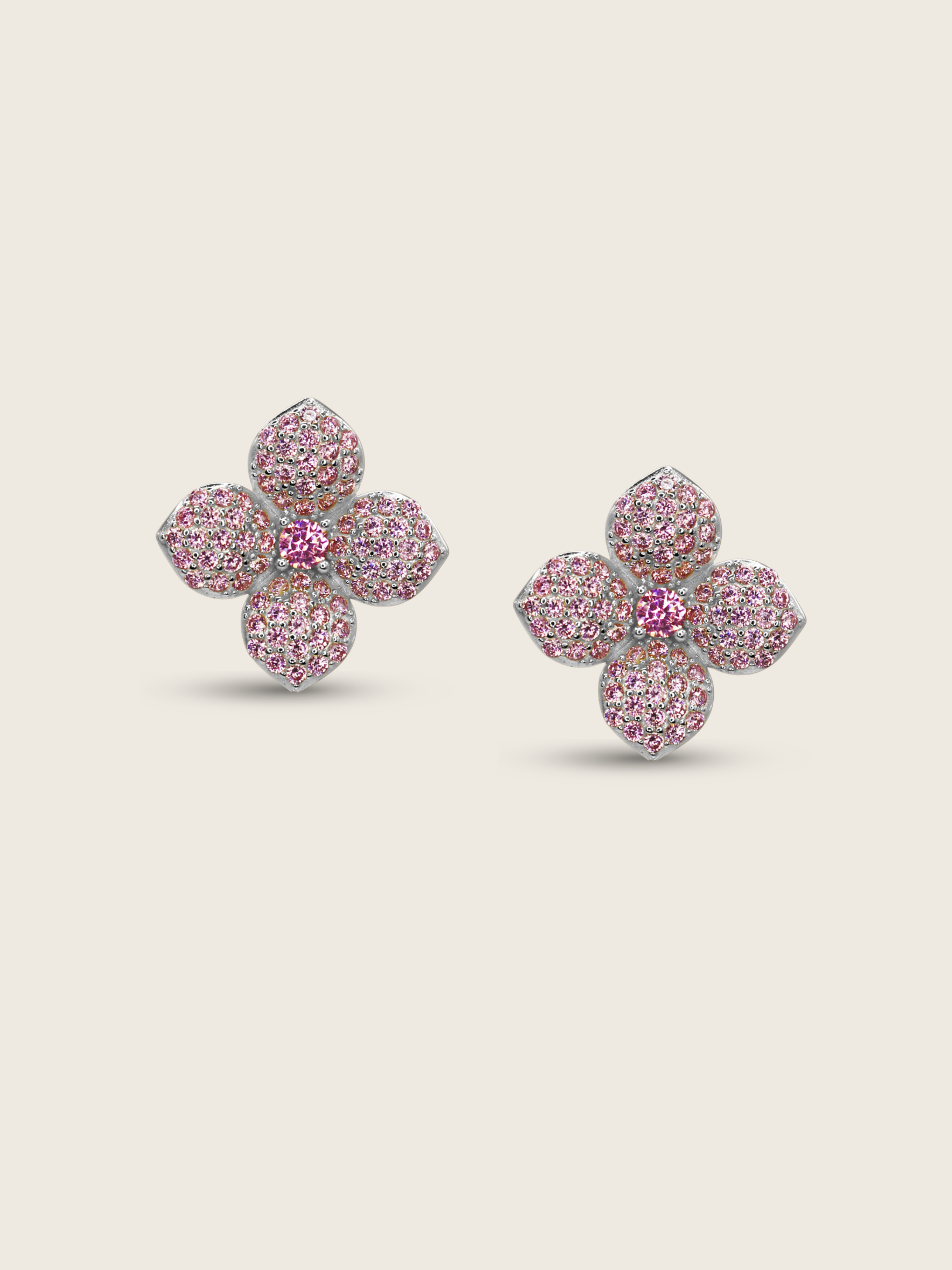 White gold plated mini hydrangea stud earrings with light pink cubic zirconia petals and pink centre stone on a neutral background, a delicate floral design ideal for soft sparkle and refined styling