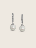 White gold drop earrings with CZ-set hoops and round freshwater pearls, elegant flatlay on cream background