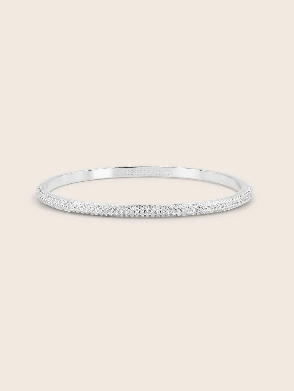 White gold plated pavé slim Christy bangle on white background. Slim half-set CZ bracelet with subtle sparkle, perfect for stacking.
